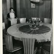 Loja Saarinen in the dining room with tablecloth of her design