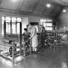 Loja Saarinen standing at the loom in her Weaving Room at nearby Studio Loja Saarineny, circa 1930