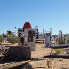 Noah Purifoy Outdoor Museum of Assemblage Sculpture. Partial shot of Bandwagon, 1995 in foreground, Old Volks at Home, 1994 and Untitled, Noah's Ark, 1992 in background, left to right. Courtesy of Noah Purifoy Foundation ©2022